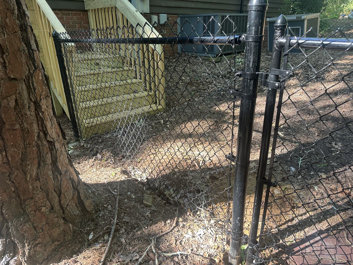 Black chain-link enclosure following the grade of the yard — Precision Palmetto, Columbia SC