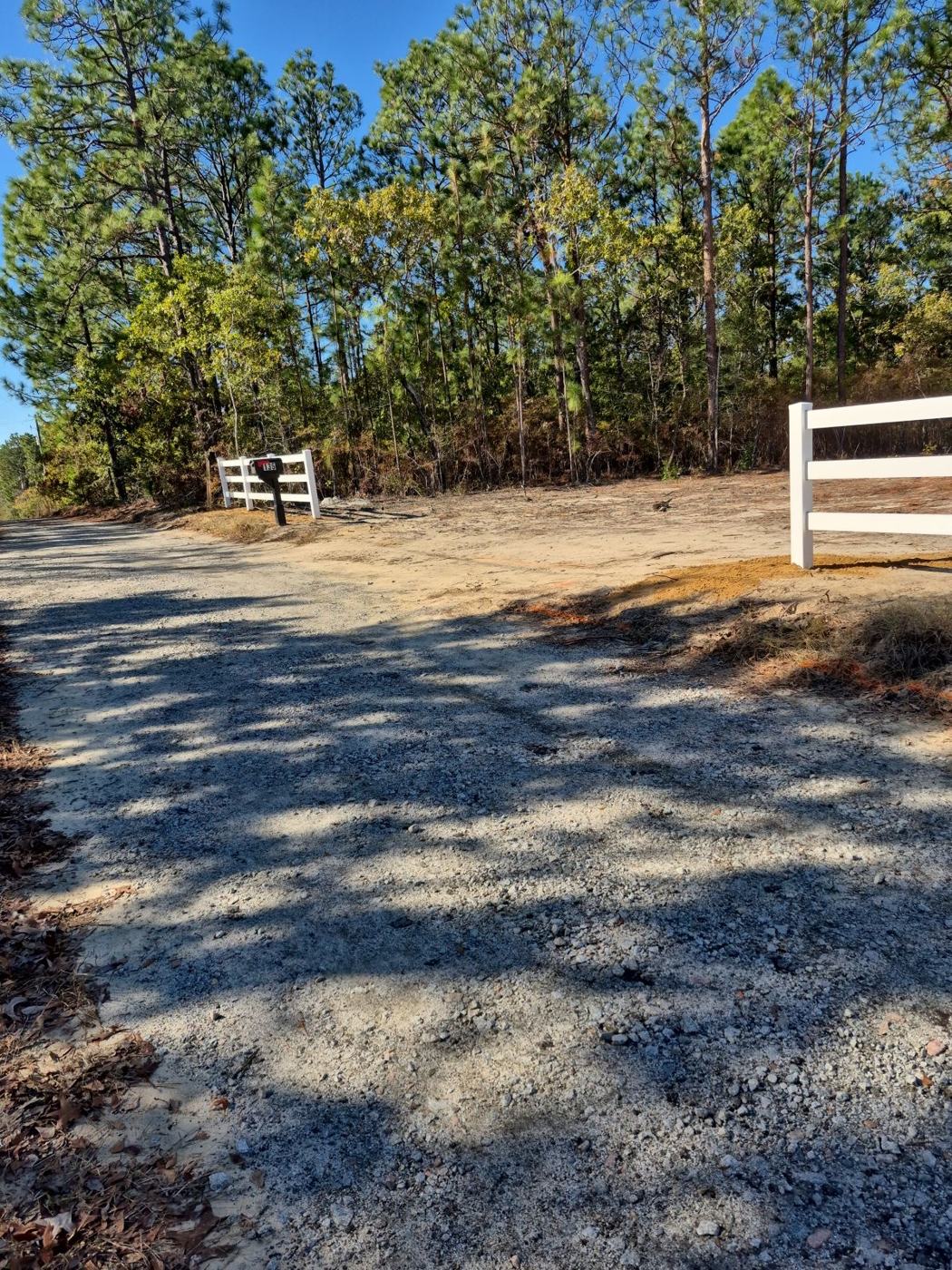 Driveway entrance framed with 3-rail vinyl fencing — Precision Palmetto, Columbia SC