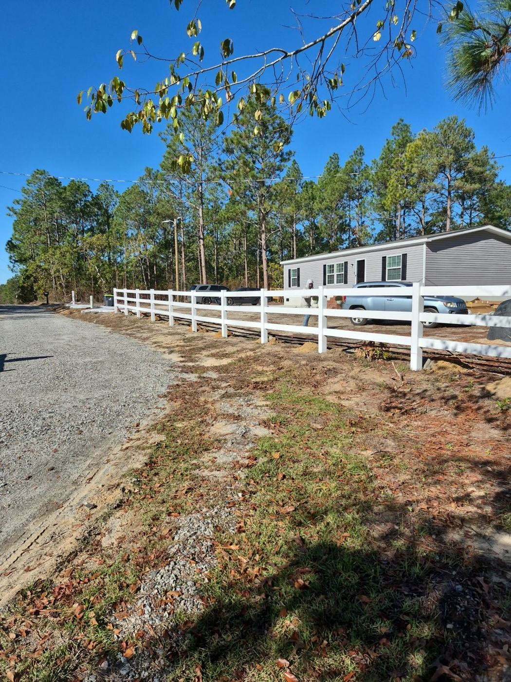 3-rail white vinyl fence along the road frontage — Precision Palmetto, Columbia SC