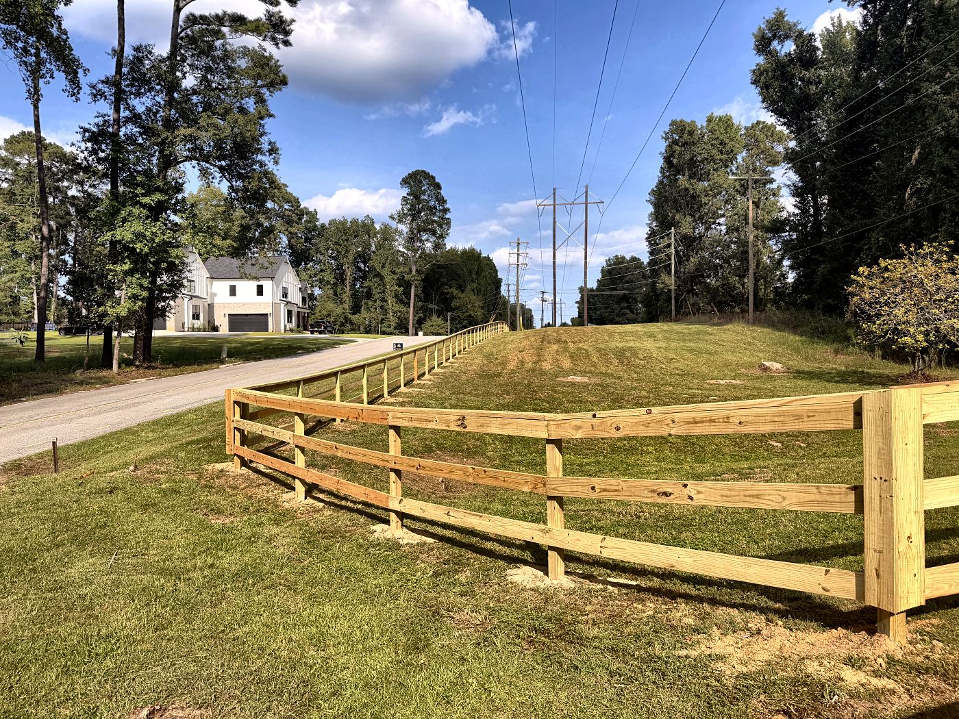Split rail fence corner run climbing the grade beside a road in West Columbia, SC — Precision Palmetto
