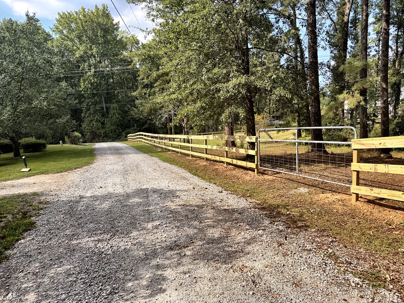 Split rail fence with a galvanized wire gate along a gravel driveway in West Columbia, SC — Precision Palmetto