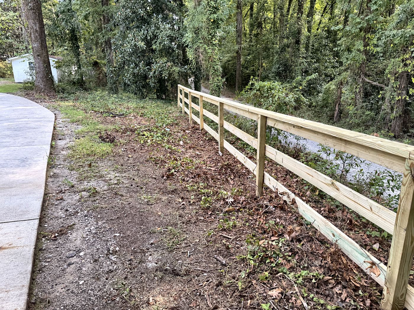Pressure-treated split rail fence with top rail along a road frontage in West Columbia, SC